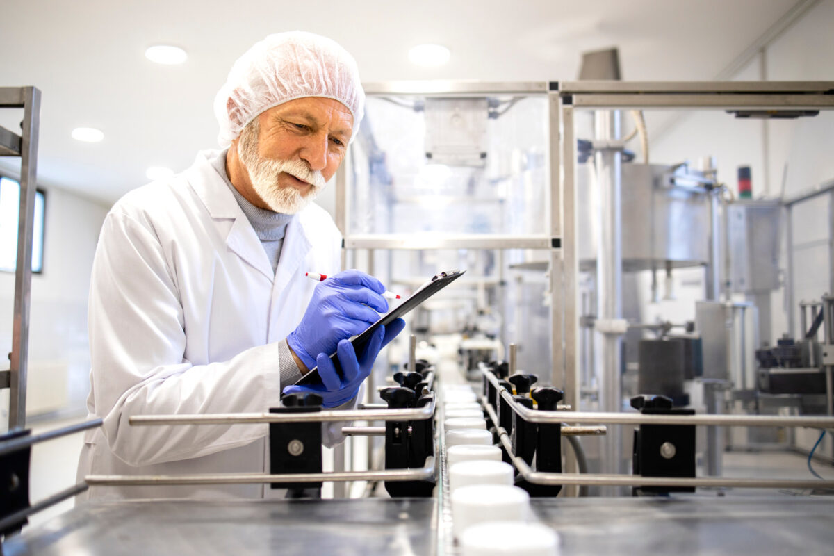 Homme qui contrôle une chaine de produits cosmétique dans un laboratoire